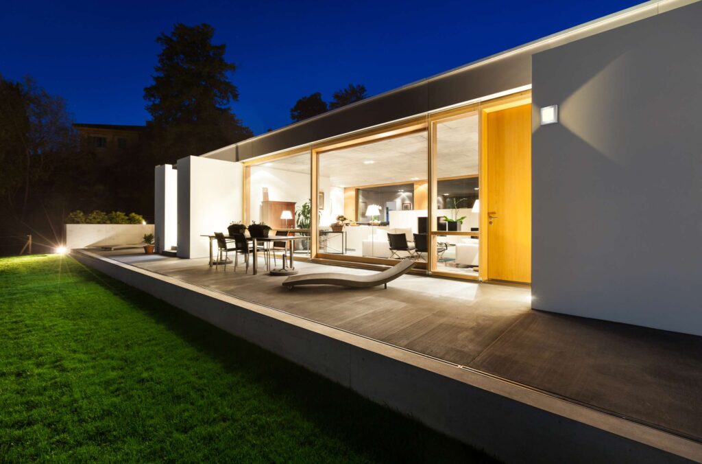beautiful modern house in cement, view from the garden, night scene